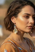 Asian woman with hand near ear showcasing clay fan drop earrings